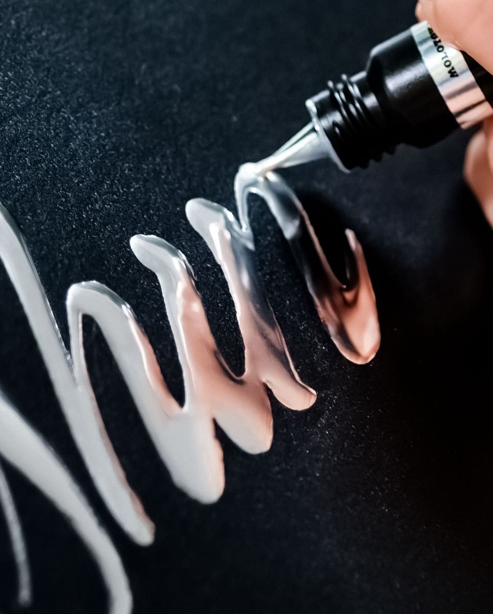 Liquid Chrome writing mirror-chrome lettering on black paper