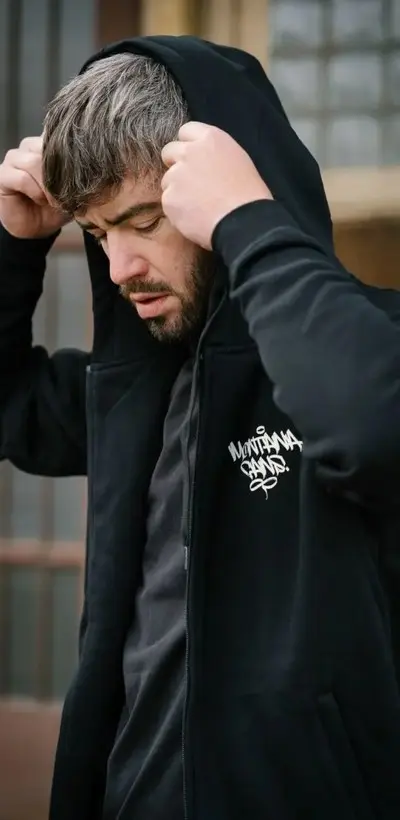 Man in a black Montana Cans zip hoodie